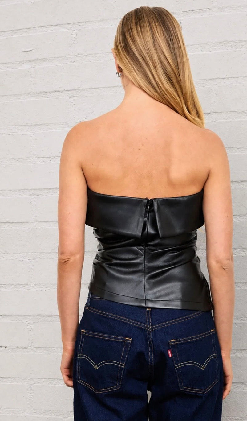 Back of a black faux leather tube top with a center zipper and ruched waist