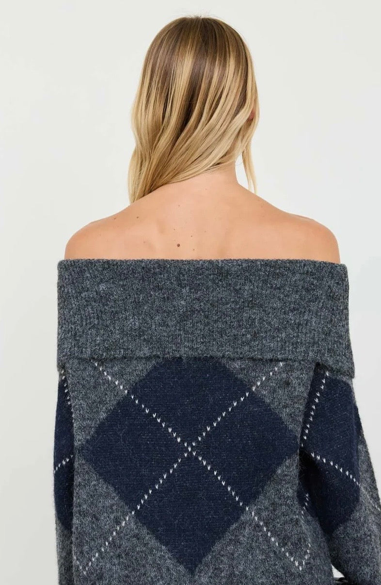 Back view of an off-the-shoulder sweater with a charcoal gray and navy argyle pattern